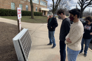 Students look at solar panel