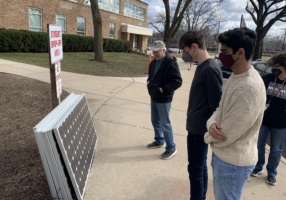 Students look at solar panel